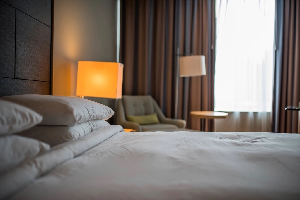 Cama tendida con lámpara encendida